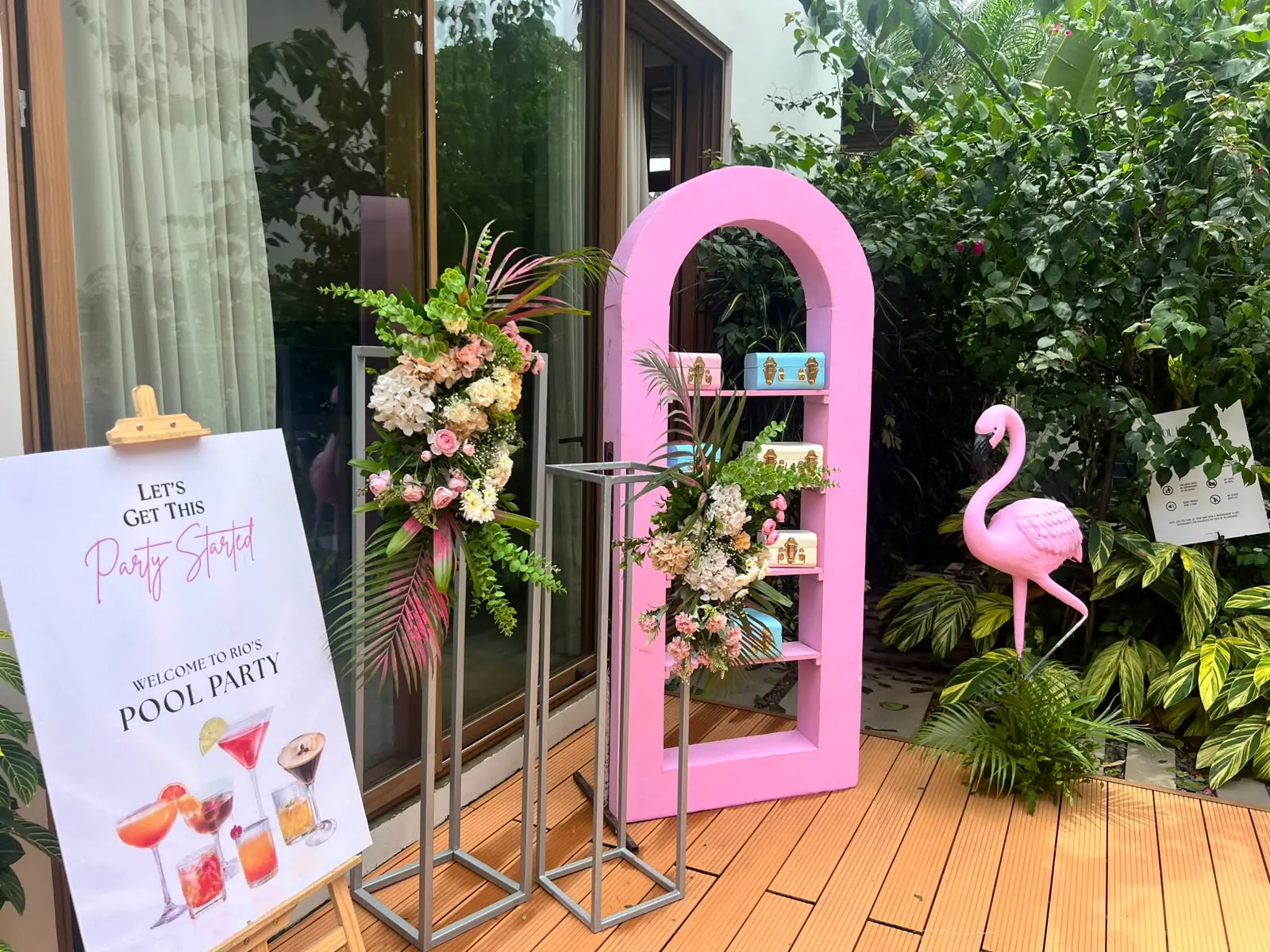 Pink Barbie-style pool party welcome arch with cocktail signage by Imagine Decorators