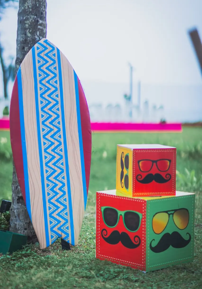Beach themed photo props with surfboard and moustache cubes at a Goa destination wedding by Imagine Decorators