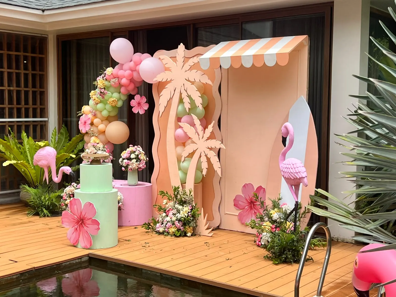 Flamingo pool floaties with pink cocktail lounge and floral parasol at a Goa villa pool party by Imagine Decorators
