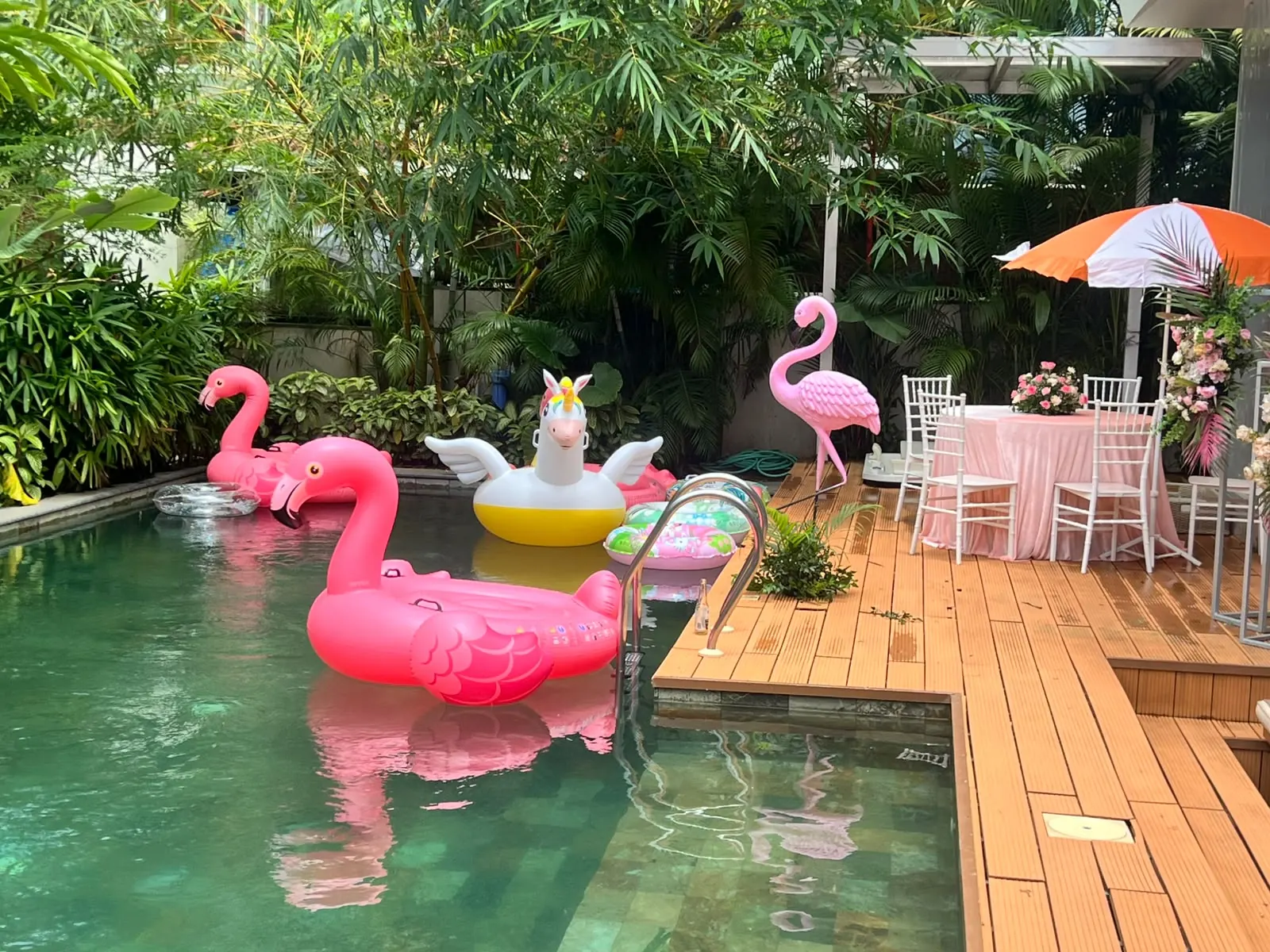 Tropical flamingo pool party stage with pastel balloon garland and palm cut-outs by Imagine Decorators Goa