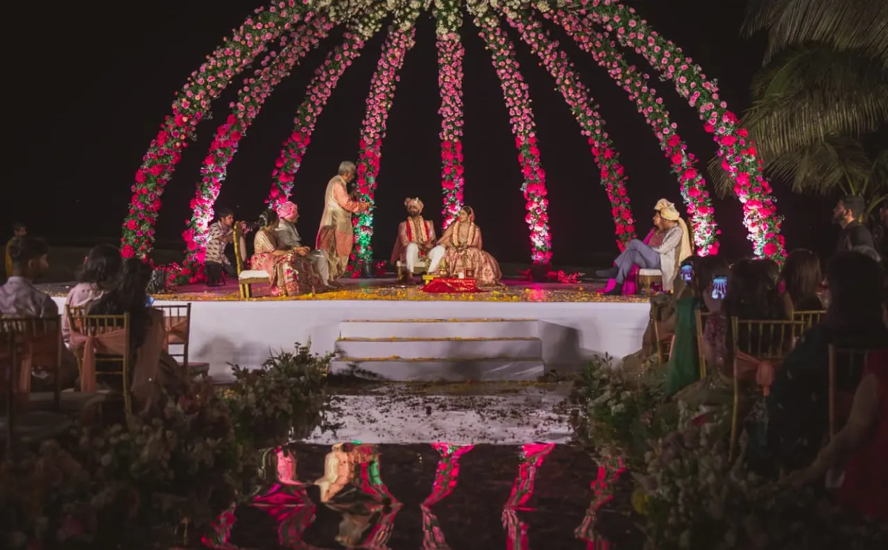 Dramatic rose dome mandap with cascading garlands at a night wedding ceremony by Imagine Decorators Goa