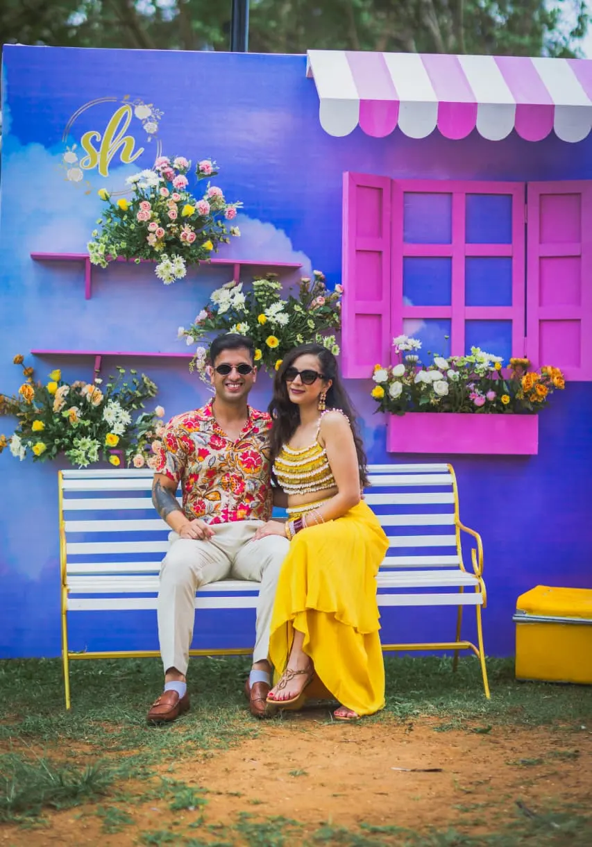 Floral shopfront photo booth with painted window and bench for a sangeet by Imagine Decorators Goa
